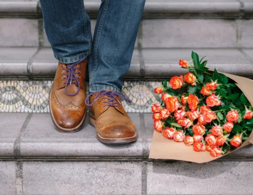 Ein Paar Budapester Schuhe neben einem Blumenstrauß