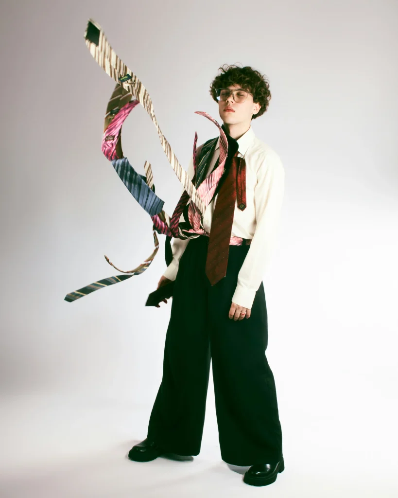 Person mit offen getragenen Krawatten und Hemd, visualisiert das Thema Krawatte binden und moderne Herrenmode