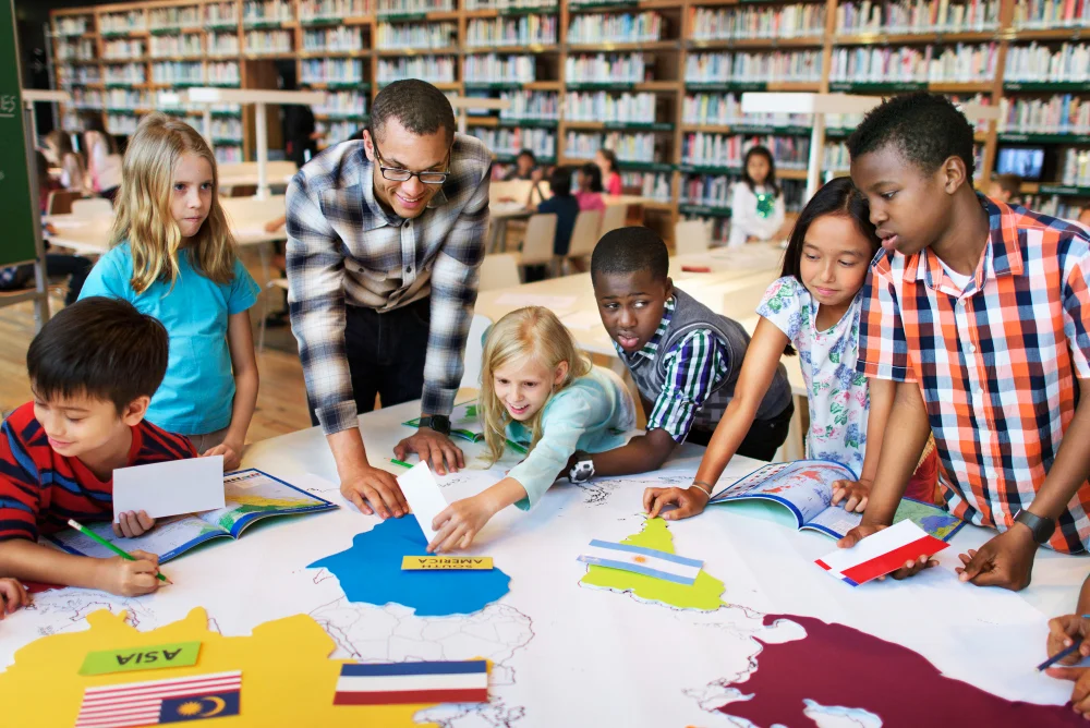 Kinder lernen gemeinsam mit einer Weltkarte und Länderflaggen