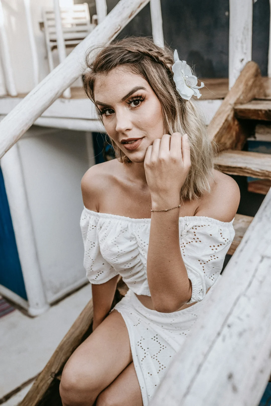 Frau mit romantischem Sommer-Make-up passend zum weißen Off-Shoulder-Outfit