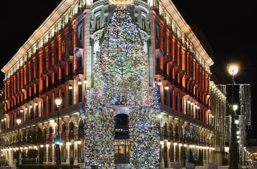 Festlich beleuchtete Fassade des Four Seasons Hotel Madrid bei Nacht im historischen Stadtzentrum