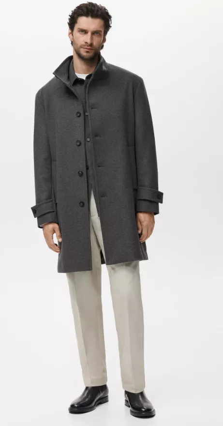 Mantel Herren grau – klassischer Wollmantel mit Steh-/Reverskragen, Knopfleiste und Riegeln am Ärmel, kombiniert mit beiger Stoffhose und schwarzen Chelsea-Boots.