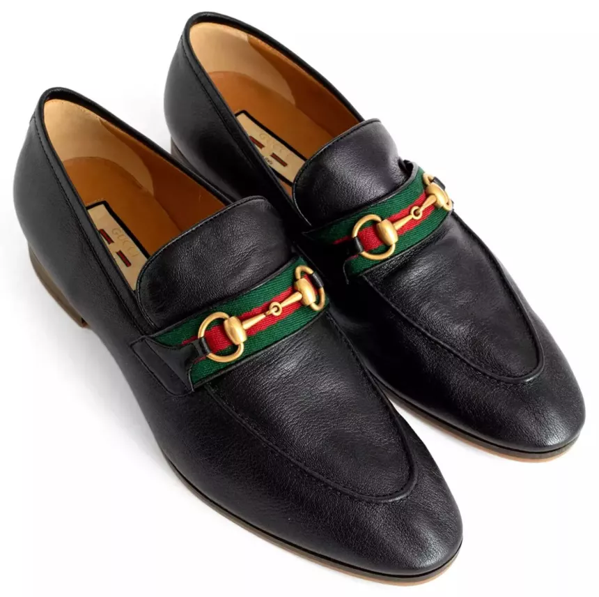 Ein Paar schwarze Gucci Horsebit Loafer mit grün-rotem Band und goldener Schnalle.