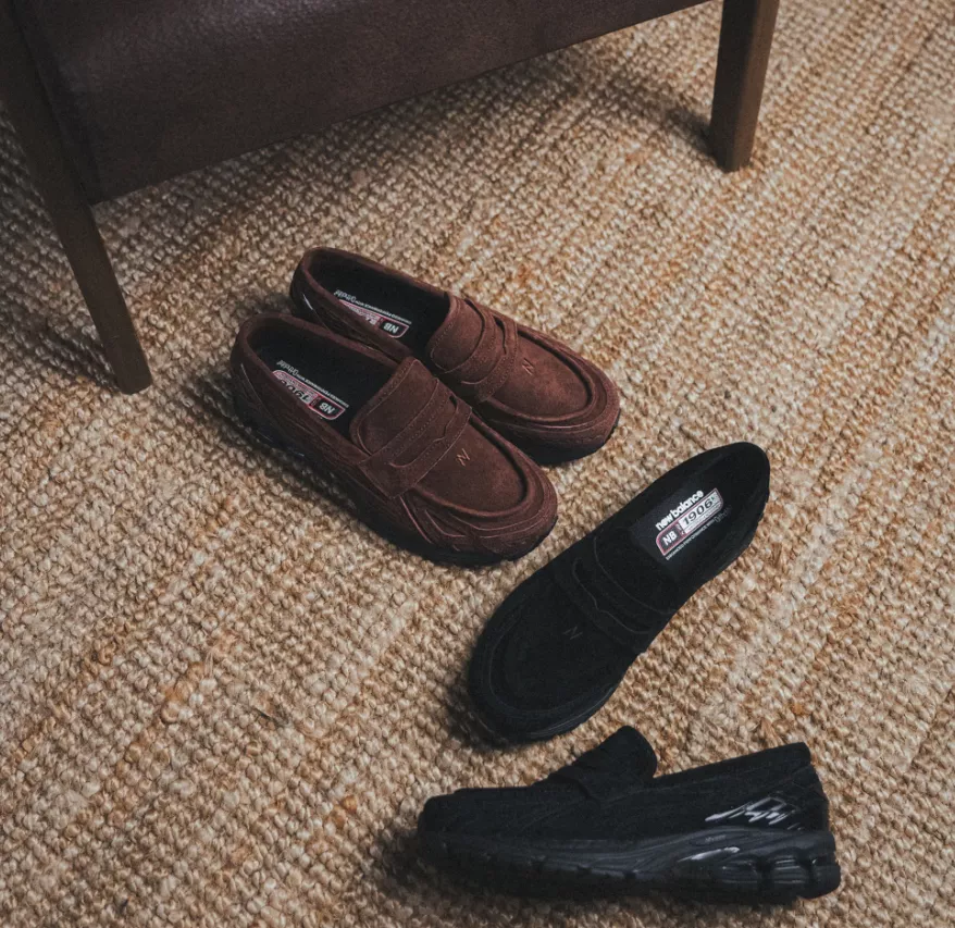 Zwei Paar New Balance 1906 Loafer, ein Modell in Braun und ein Modell in Schwarz, auf einem Teppich arrangiert.