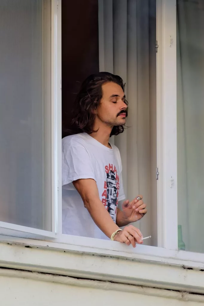 Ein junger Mann mit Schnurrbart und Spitzbart – selbstbewusster Look in einem künstlerischen Schwarz-Weiß-Porträt.