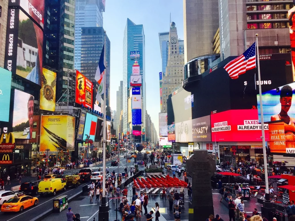 Times Square bei Tag mit leuchtenden Billboards, Taxis und Menschenmengen – New York Fashion Week 2025 Stimmung im Herzen Manhattans.