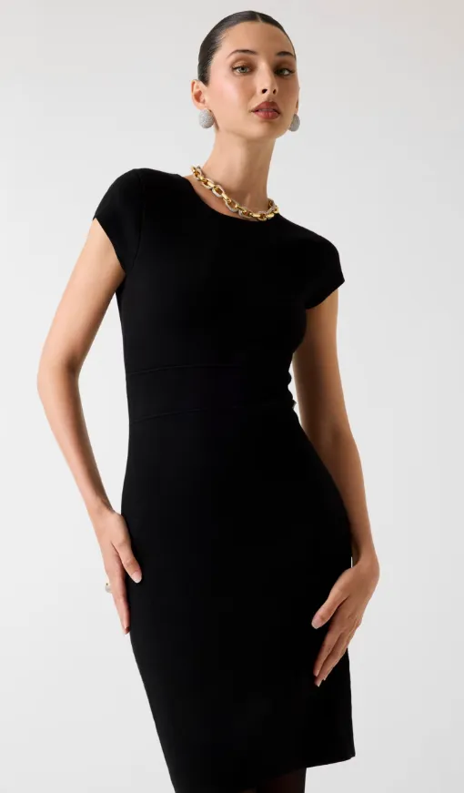 Frau im schwarzen Strick-Etuikleid mit Cap-Sleeves, Goldkette und Steckerohrringen – eleganter Business-Abend-Look.