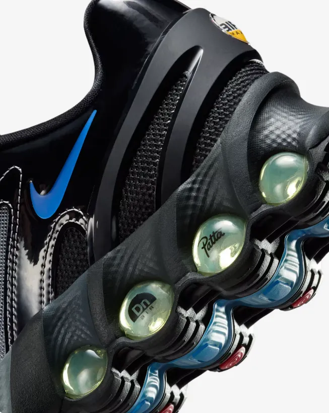 Patta x Nike Air Max DN8 in Black und Metallic Silver mit sichtbaren Dynamic-Air-Tubes und blauem Swoosh im Close-up.