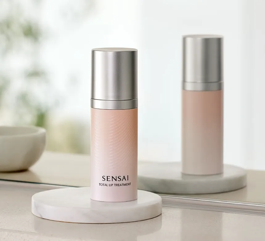 Luxus-Lippenpflege im Bad: SENSAI Total Lip Treatment auf rundem Marmortray mit Spiegelreflexion – elegantes Packaging in Rosé und Silber