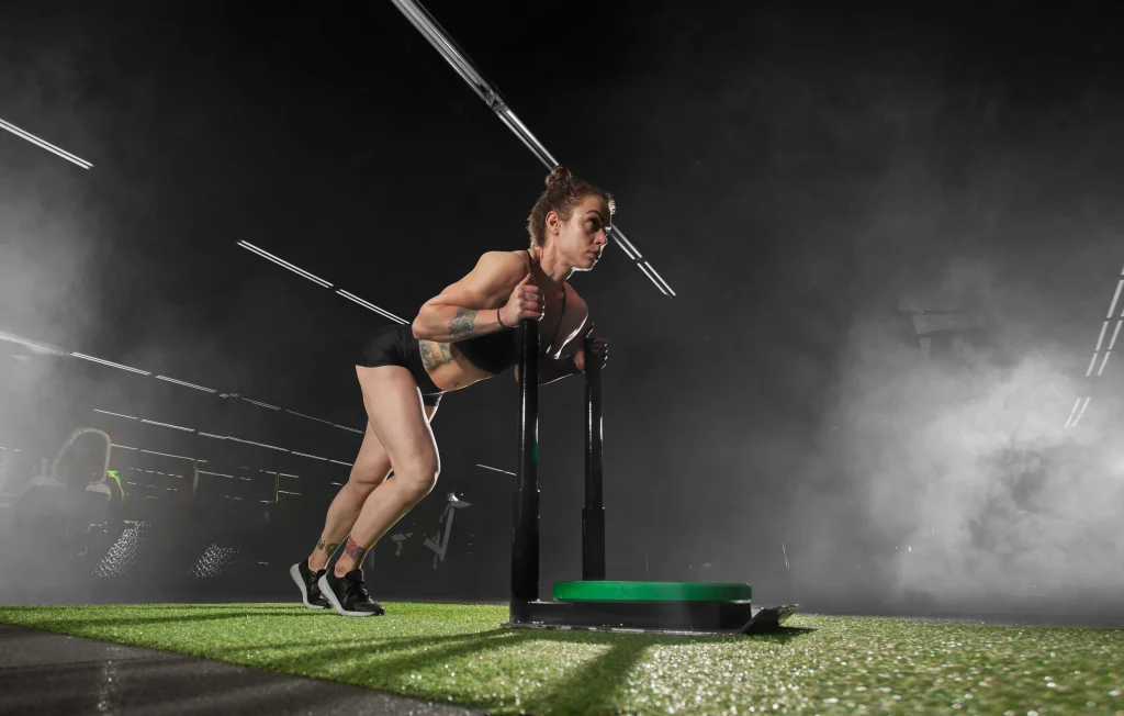 Hyrox Training – Sled Push auf Kunstrasen mit vorwärts geneigter Haltung