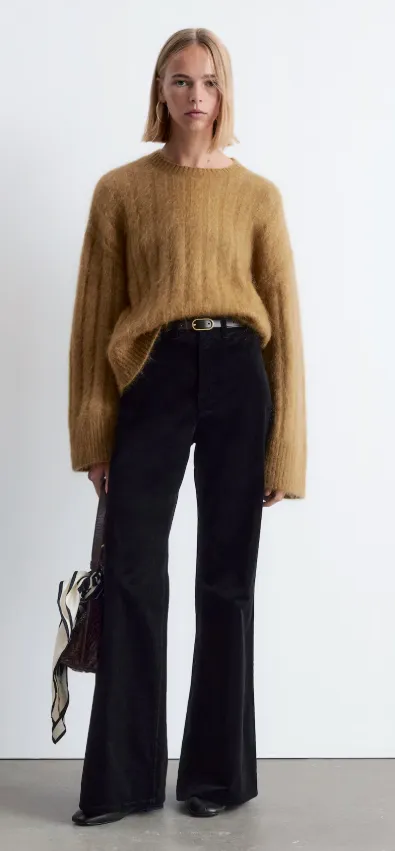 Cordhose Damen Herbstrend: schwarze Wide-Leg-Cordhose mit karamellfarbenem Mohair-Pullover, Gürtel und Lederstiefeln – moderner Herbstlook