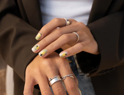 French Nails auf kurzen Nägeln: Nude-Basis mit geschwungener weißer Spitze, feinem Glitzer und dezenten Linien-Details.