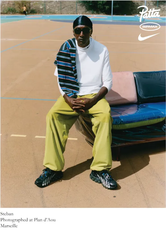 Steban trägt den Patta x Nike Air Max DN8 auf einem Outdoor-Court in Marseille, sitzend auf einem Sofa.