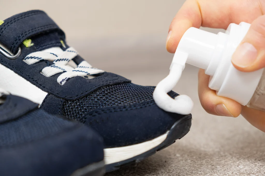 Sneaker waschen: Reinigungsschaum wird auf blaue Stoff-Sneaker aufgetragen, um Verschmutzungen zu lösen