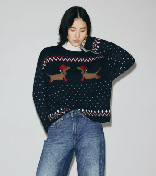 Damen-Weihnachtspullover in Dunkelblau mit Dackelmotiv, kombiniert mit Jeans und weißem Rollkragen.