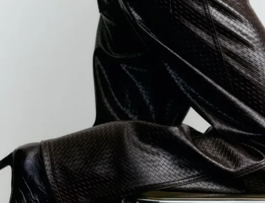 Dunkelbraune Lederhose mit strukturierter Oberfläche in Nahaufnahme, kombiniert mit dunklem Oberteil und Absatzschuh.