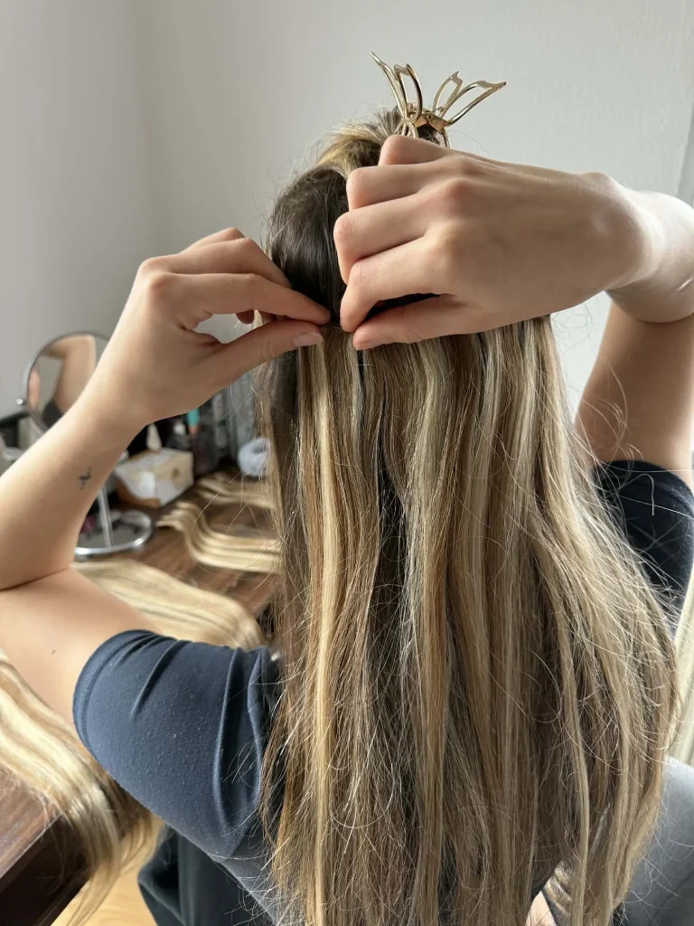 Einklicken der nahtlosen Clip-In Extensions von Hickenbick Hair ins Eigenhaar.