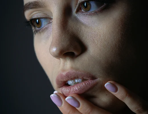 Frau mit dezenten French Nails in zartem Rosé mit weißer Spitze, natürliche Maniküre und gepflegte Nägel