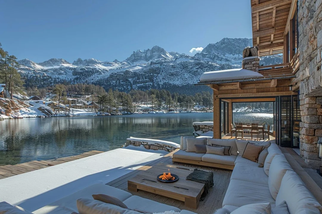 Exklusives Chalet in Italien mit Blick auf einen Bergsee und schneebedeckte Alpen im Winter.