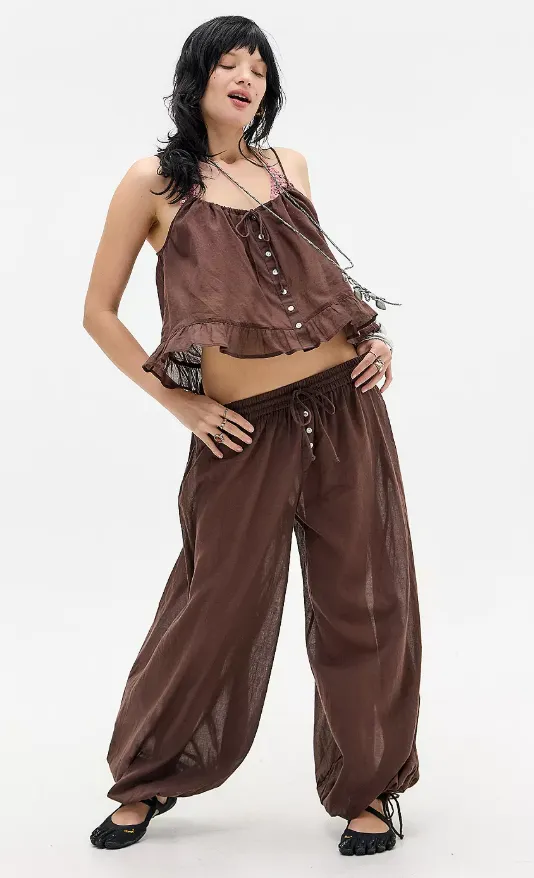 Braune Ballonhose mit weitem Bein und schmal zulaufendem Saum, kombiniert mit einem kurzen Top im gleichen Farbton.