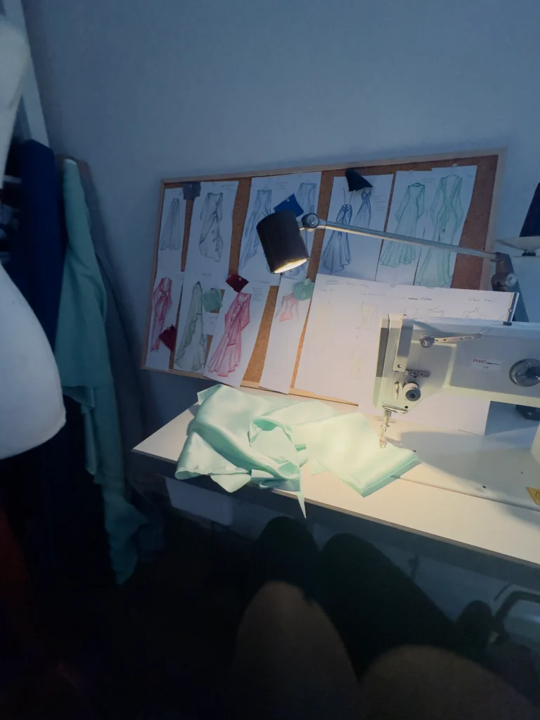 Seide im Atelier: Entwurfszeichnungen und Arbeit an einem Seidenstoff an der Nähmaschine