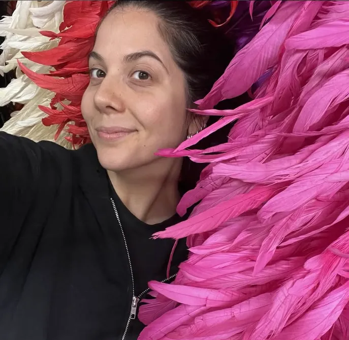 Natali Germanotta in einer Nahaufnahme mit pinkfarbenen Federn in ihrem Atelier