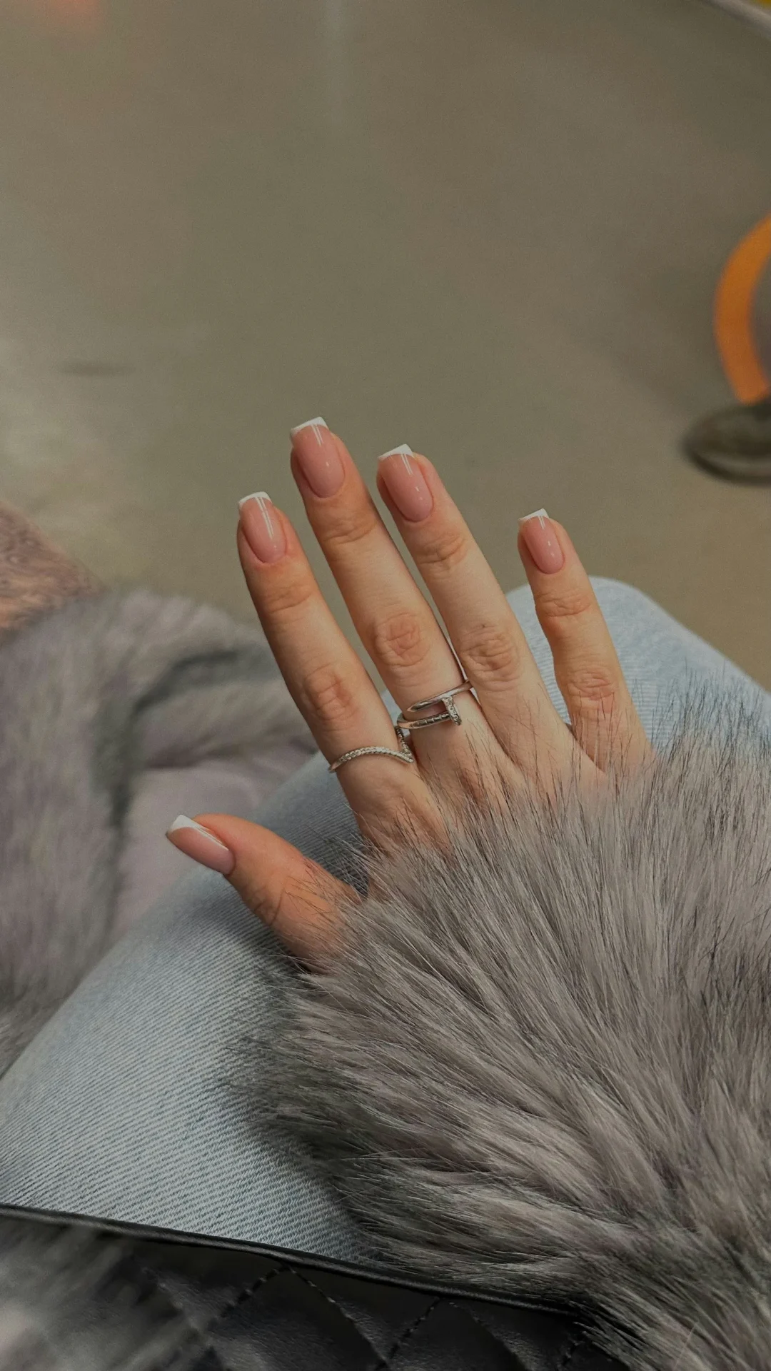 Gepflegte Fingernägel mit natürlicher French-Maniküre und glänzender Oberfläche als Beispiel für sorgfältige Nagelpflege.