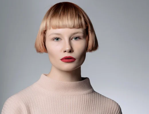 Micro Bob mit geradem Pony und klarer Linienführung bei einer Frau vor neutralem Hintergrund