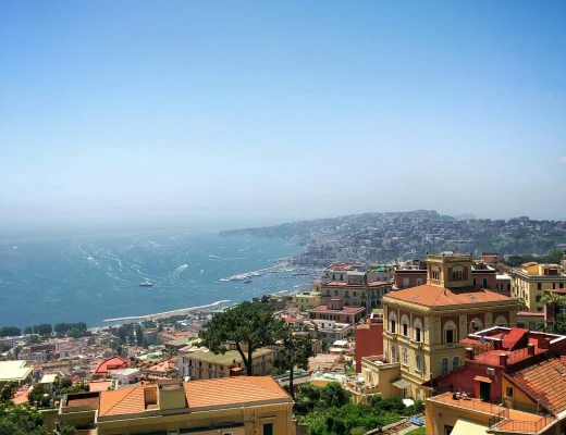 Panoramablick über Neapel mit bunten Häusern, der Bucht von Neapel und dem Tyrrhenischen Meer an einem sonnigen Tag