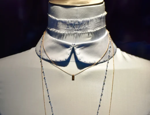 Weiße Bluse mit Stehkragen und feinen Nähten, kombiniert mit filigranen Ketten