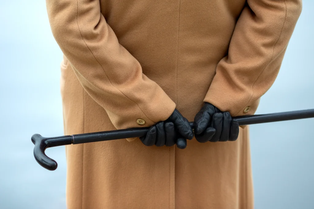 Schwarze Lederhandschuhe als klassisches Accessoire zu einem camel-farbenen Mantel