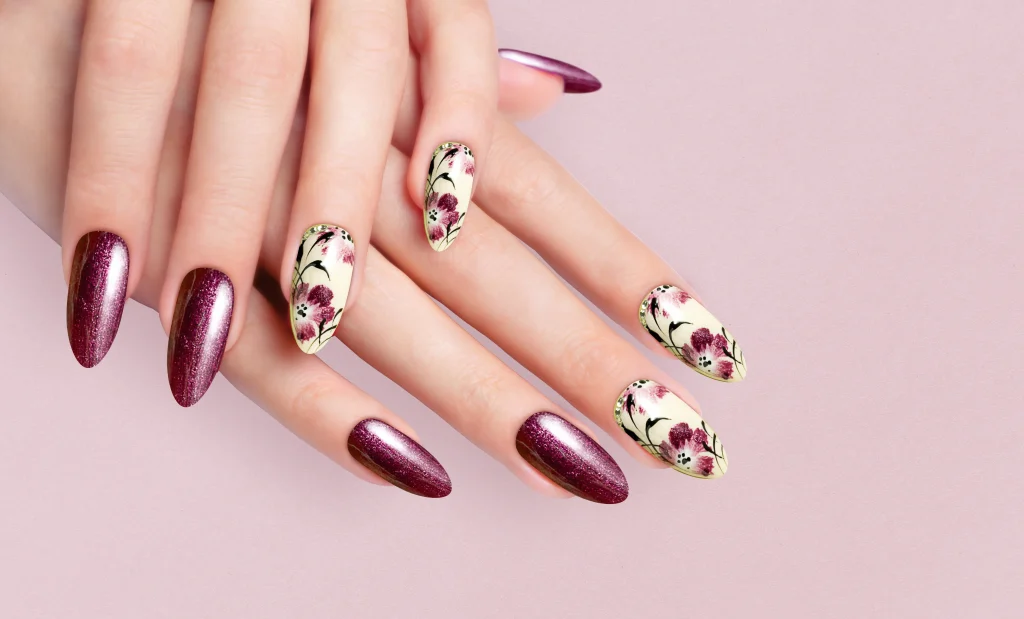 Frühlingsnägel 2026 mit floralen Details in Creme und Beerentönen, elegante Almond-Maniküre mit Blütenmotiven