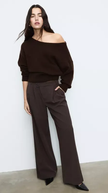 Model tr&auml;gt braunen Off-Shoulder-Pullover mit brauner Hose &ndash; eleganter Look in der Trendfarbe Braun 2026
