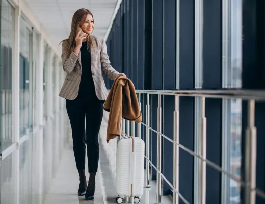 Eine Frau im stilvollen Outfit mit einem Koffer am Flughafen