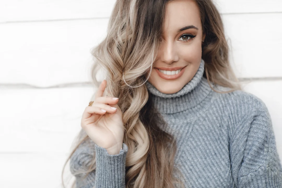 Frau mit weichen Balayage-Strähnen in Blond-Braun mit natürlichem Farbverlauf und sanften Wellen