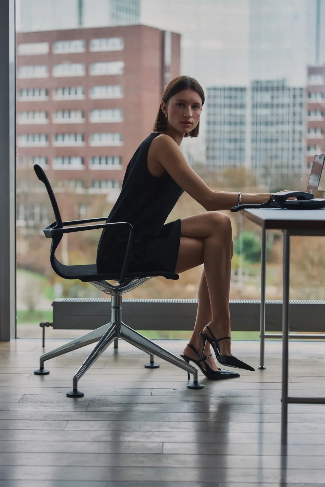 Model im schwarzen minimalistischen Kleid aus der Everly SS26 Kollektion von About You.