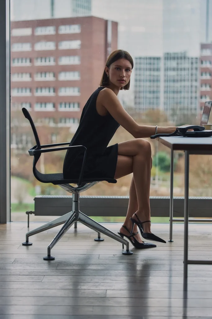 Model im schwarzen minimalistischen Kleid aus der Everly SS26 Kollektion von About You.