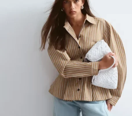 Model in einem gestreiften ASOS-Outfit mit weißer Tasche