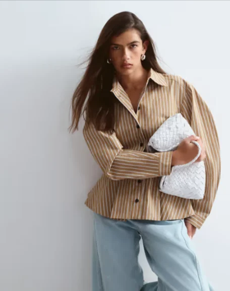 Model in einem gestreiften ASOS-Outfit mit weißer Tasche
