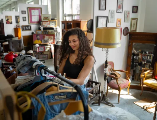 Eine junge Frau durchstöbert Second-Hand-Kleidung auf einer Plattform