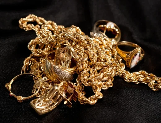Ein Haufen Goldschmuck, darunter Trauringe, Ketten und Ohrstecker