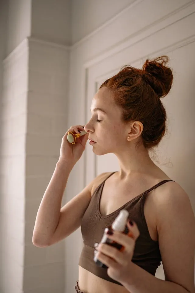 Frau mit Jade-Roller und Face Mist bei einer modernen Micro-Beauty-Routine 2026