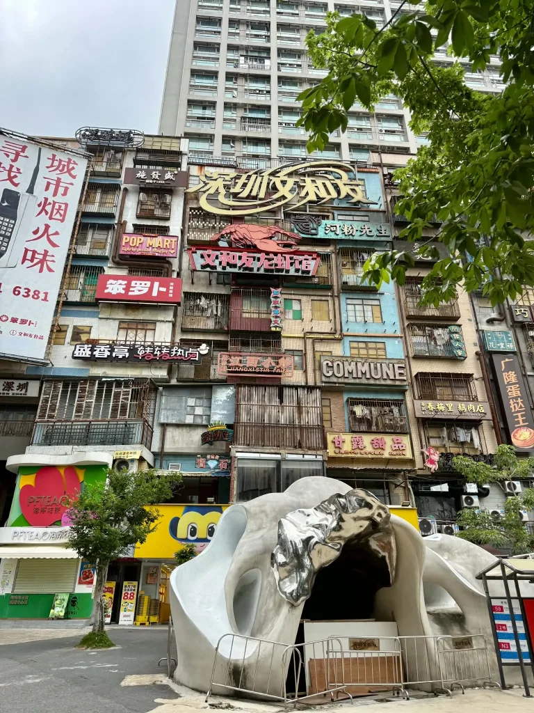 Ein modernes Gebäude in Shenzhen mit einer futuristischen Skulptur im Vordergrund