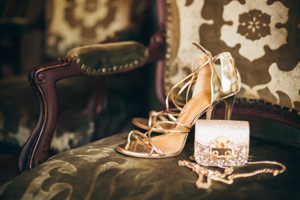 Goldene Riemchensandalen mit Absatz und glitzernder Abendtasche als eleganter Sandalen Trend 2026