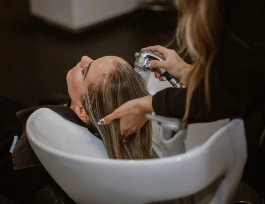 Friseurin wäscht Haare im Salon