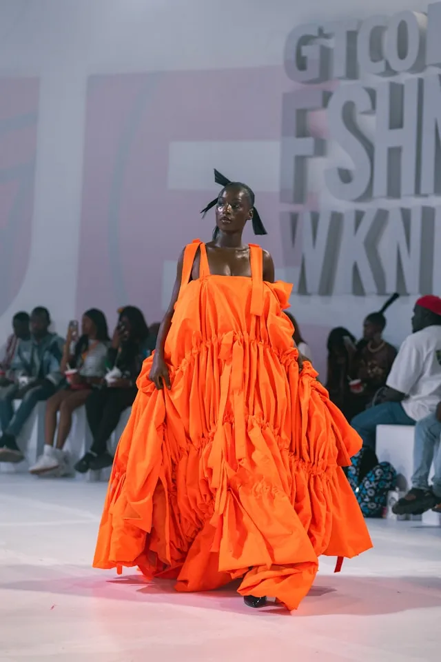 Außergewöhnliches orangefarbenes Kleid mit übergroßem Volumen und skulpturaler Silhouette auf einer Fashion Week