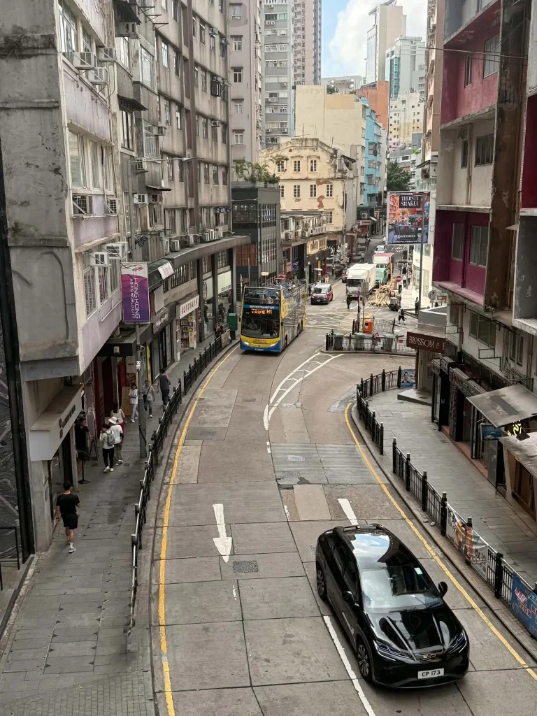 Straßenszene in Hongkong mit typischer Bebauung und Doppeldeckerbus