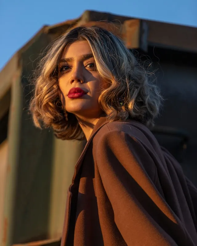 Frau mit welligem Long Bob und sanften 70s Waves im Abendlicht
