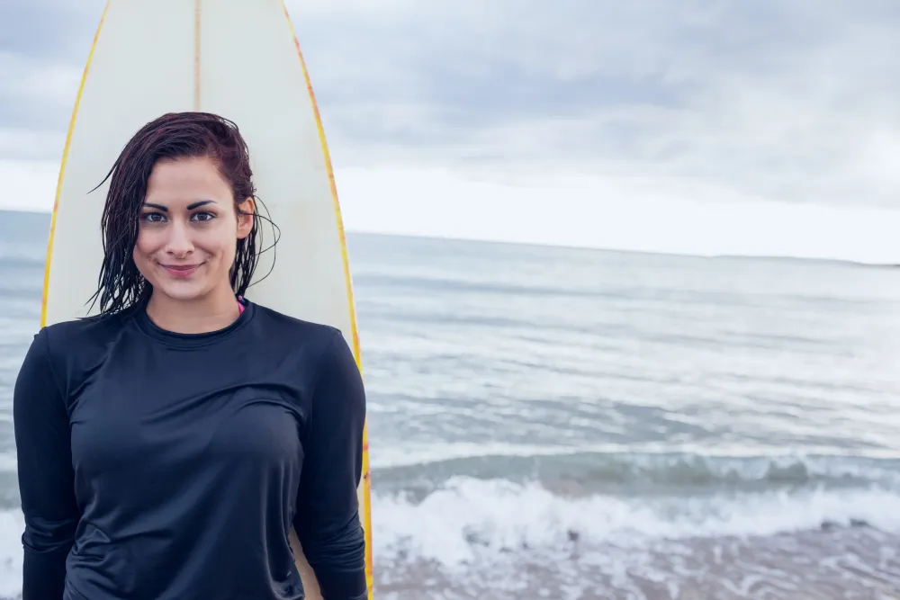Surferin mit Surfbrett am Strand