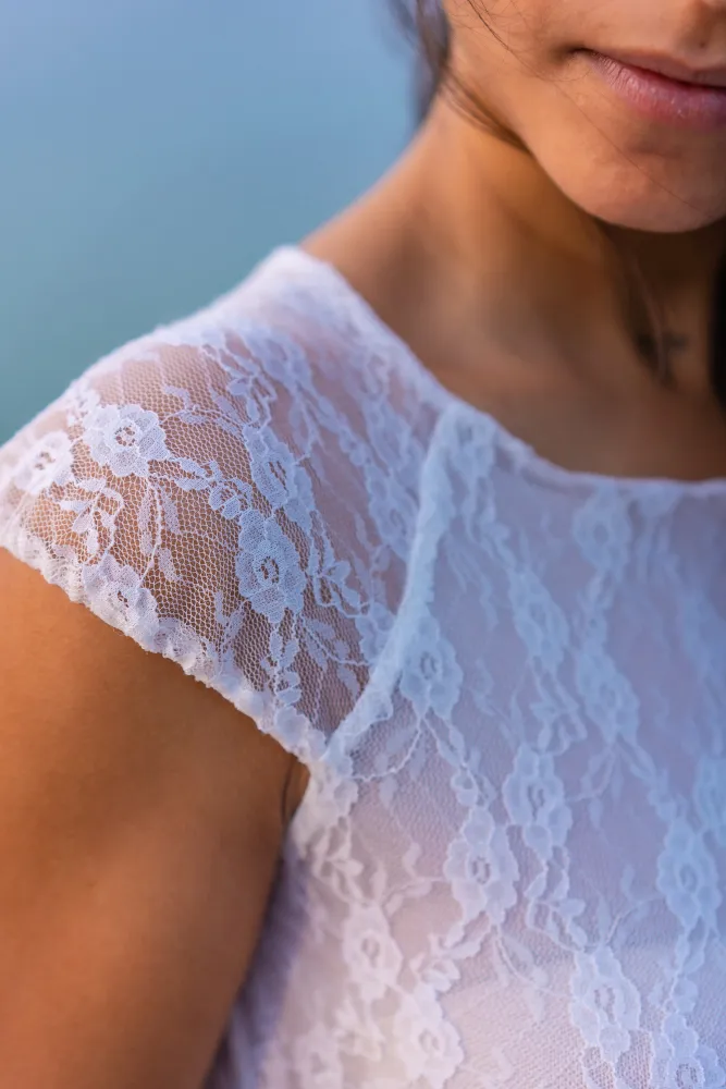 Nahaufnahme eines weißen Spitzentops mit floraler Spitze als Modetrend im Sommer 2026
